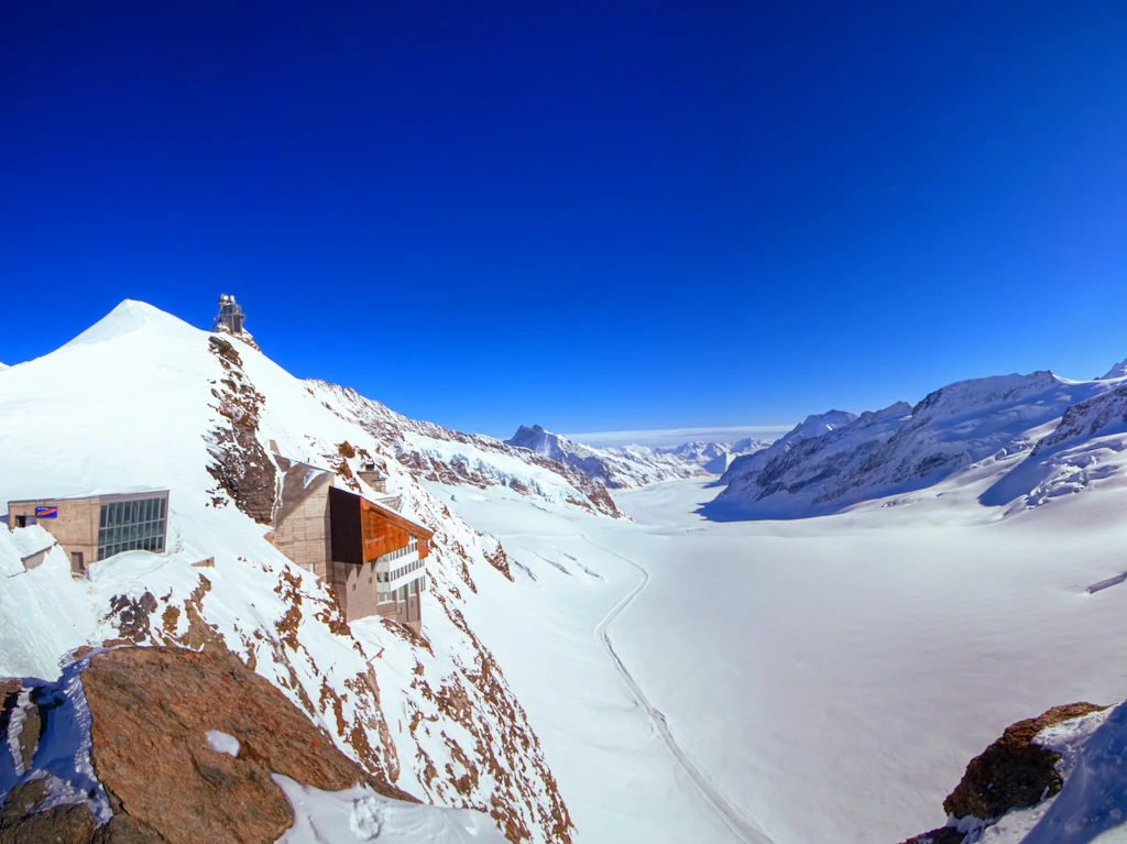 Jungfraujoch A view of the Jungfraujoch station and the Jungfraufirn glacier, part of the Jungfrau-Aletsch Unesco World Heritage Site. The station building is built into the side of the cliff face.