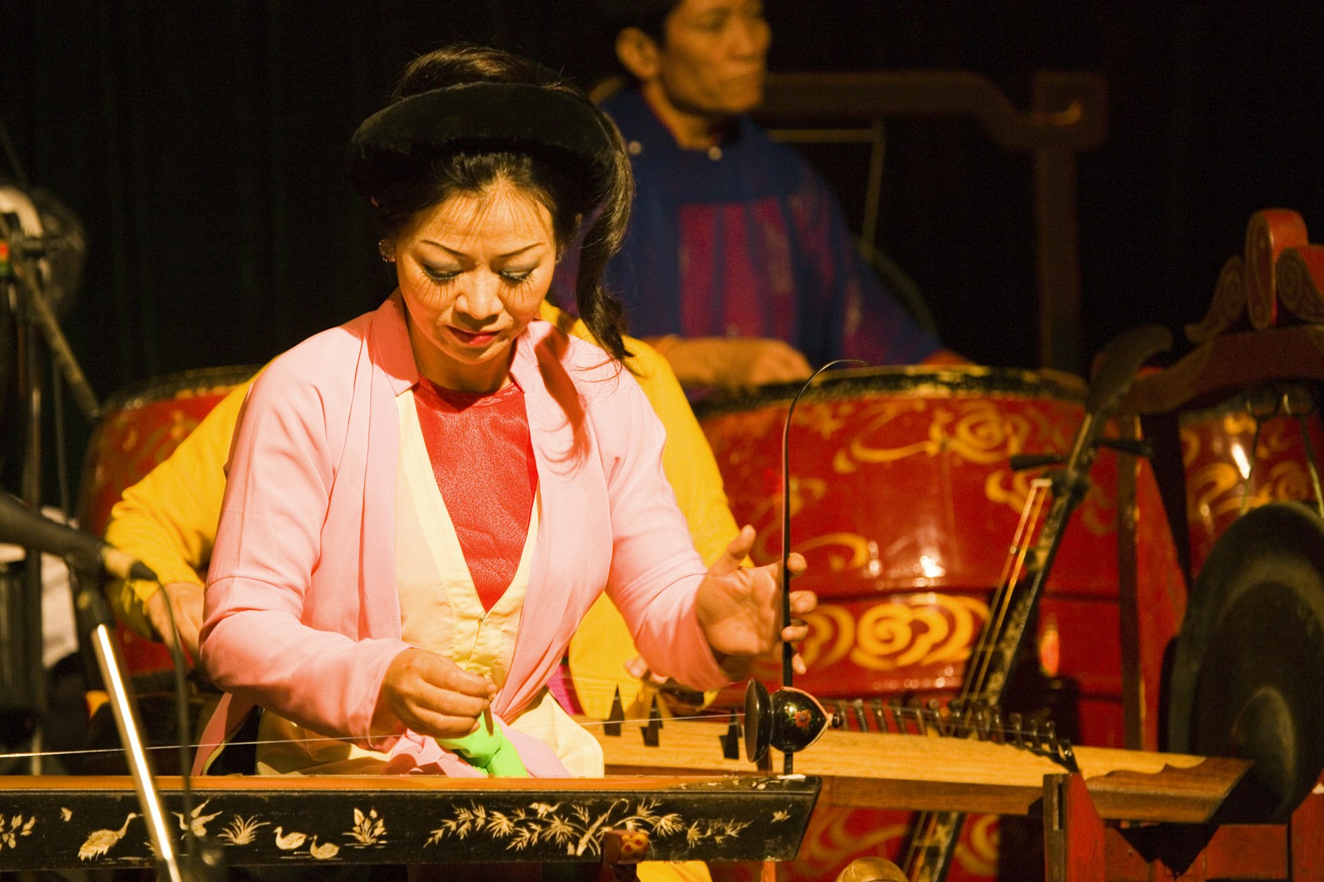 Musician playing traditional instrument at a water puppet theatre