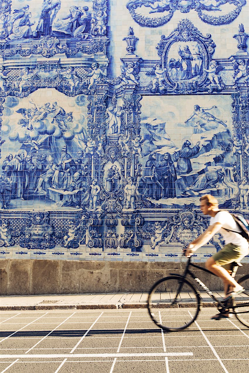 LPT0219_034.jpg A male cyclist rides past Azulejo tiles on the church walls of Capela das Almas.