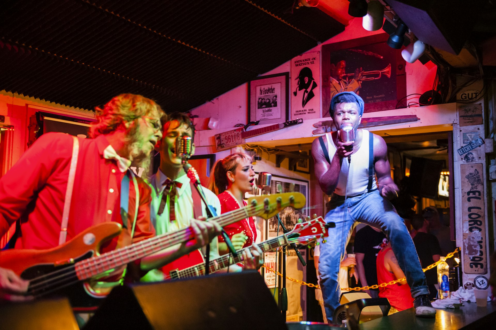 A band playing in a bar under colorful lights