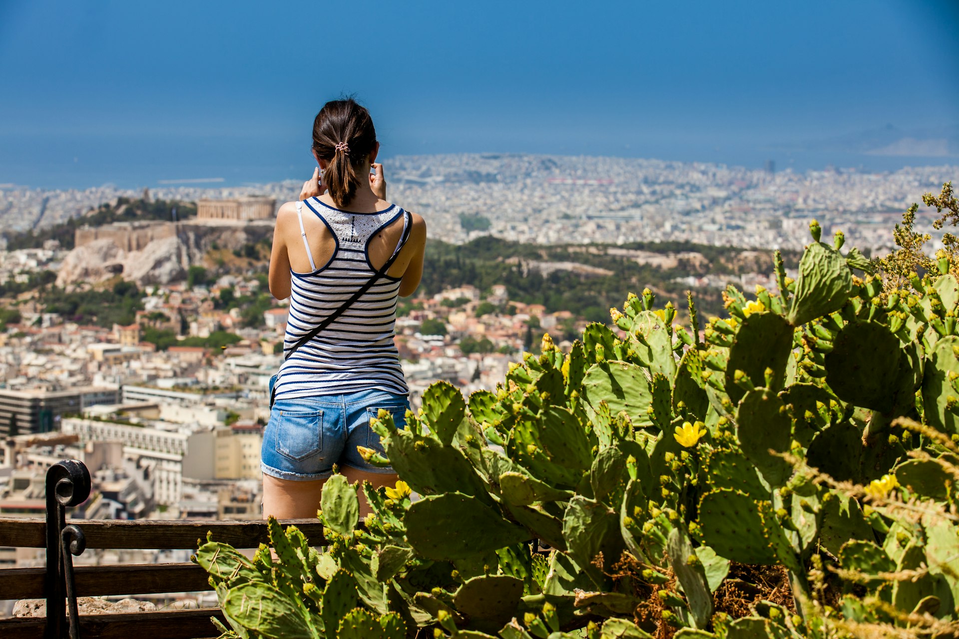 Young woman taken a picture of the city of Athens from the Mount Lycabettus a Cretaceous limestone hill