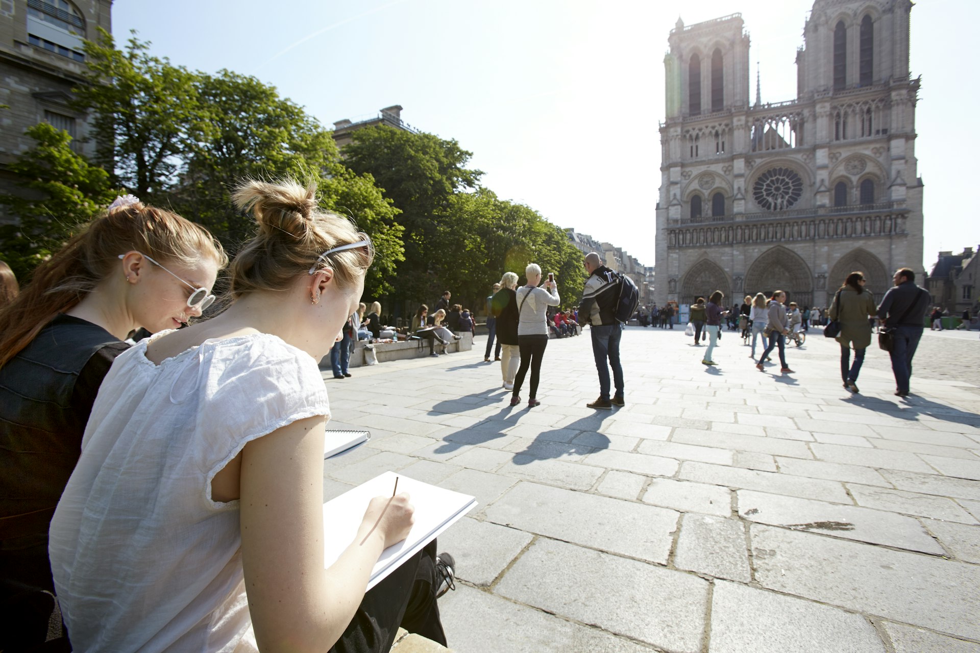 Young artists sketching Notre Dame Paris