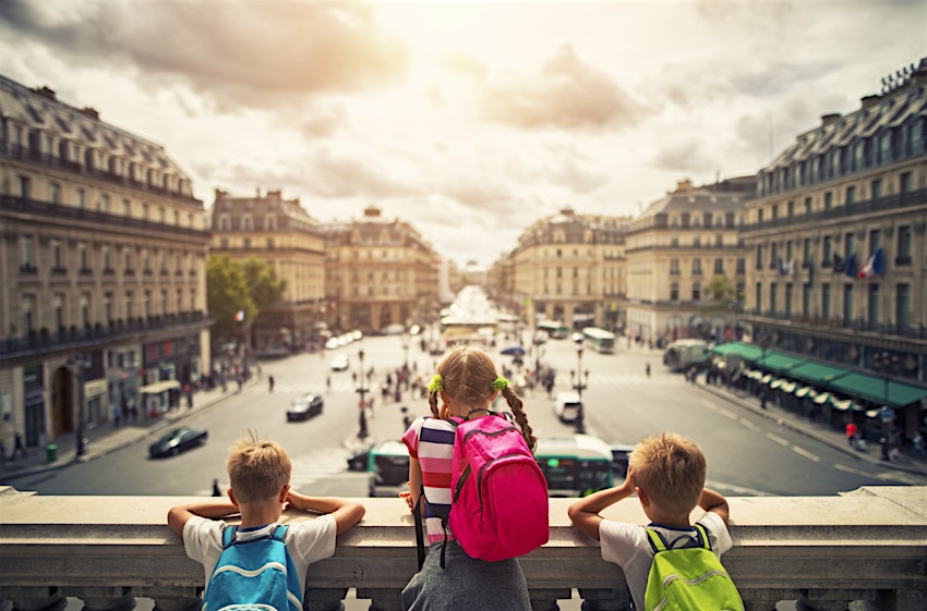 Three kids visiting Paris. They are looking from the balcony of Paris Opera at the place de l'opera. The girls is aged 9 and her brothers are aged 6