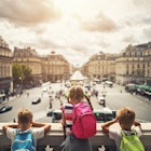Three kids visiting Paris. They are looking from the balcony of Paris Opera at the place de l'opera. The girls is aged 9 and her brothers are aged 6.