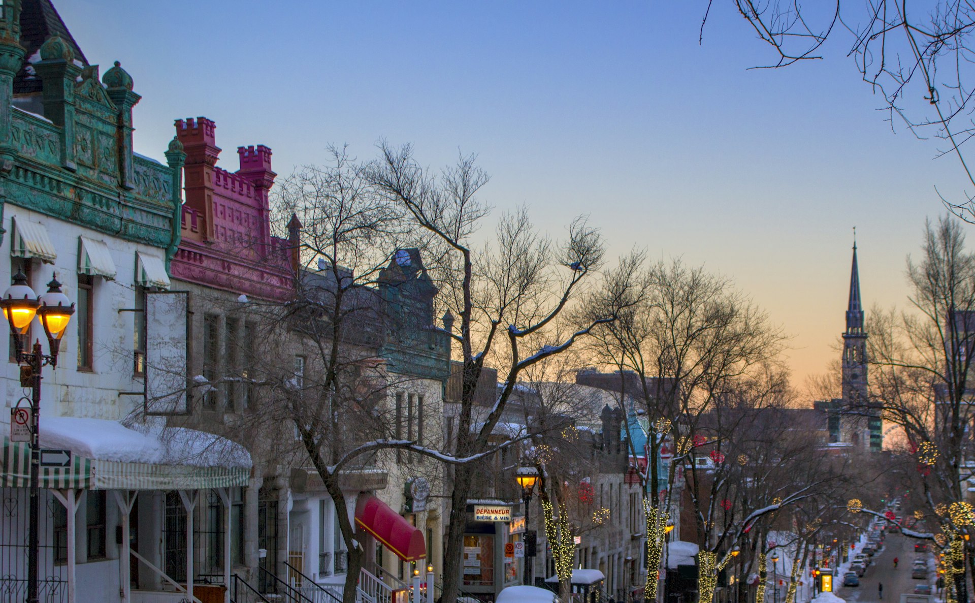 Late afternoon winter view looking down Saint-Denis street toward the shops and restaurants of the Quartier Latin in Montreal, Quebec, Canada. The spire of the former Saint-Jacques church can be seen in the background, now integrated into the campus of the Université du Québec à Montréal 