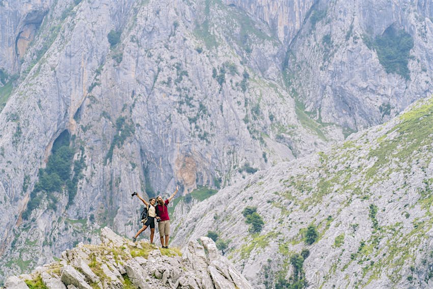 Carefree couple admiring the view while standing on mountain at Ruta Del Cares, Asturias, Spain