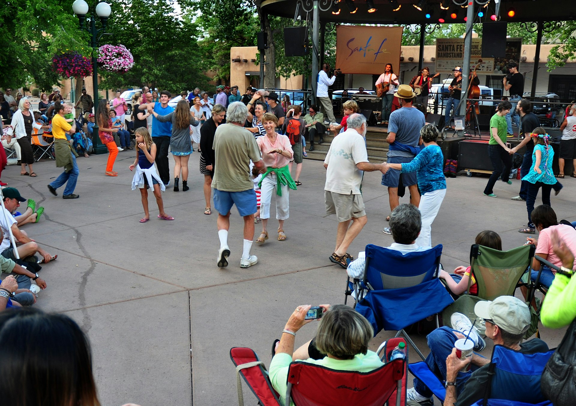 Dancers and spectators enjoy a summer music concert in the historic Plaza in downtown Santa Fe, New Mexico.