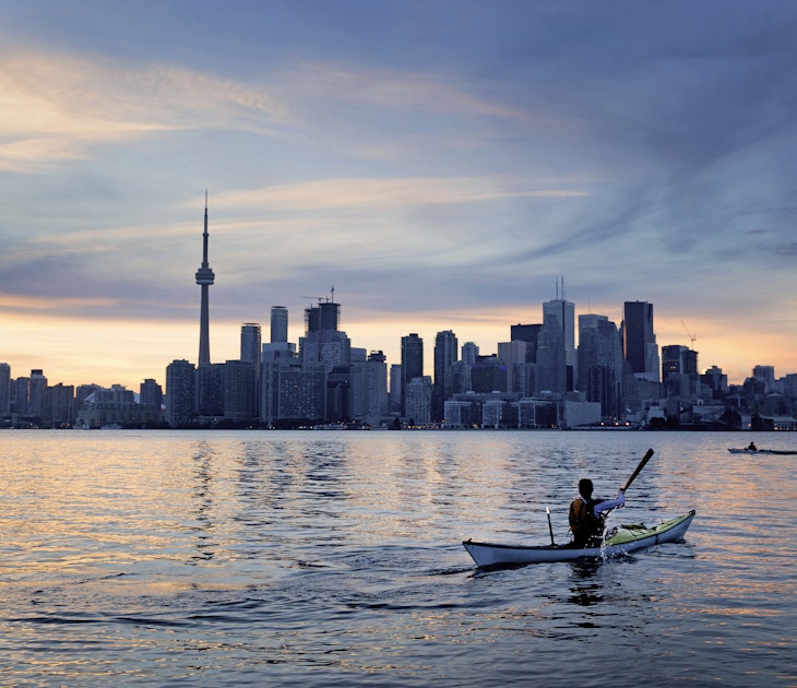 A kayaker in front of a city skyline
