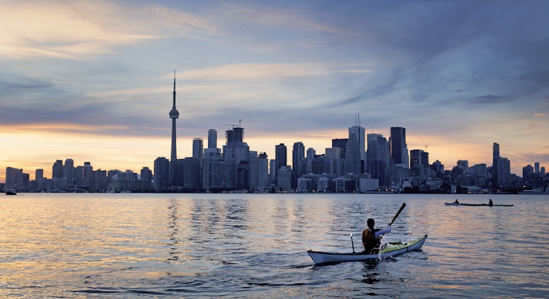 A kayaker in front of a city skyline