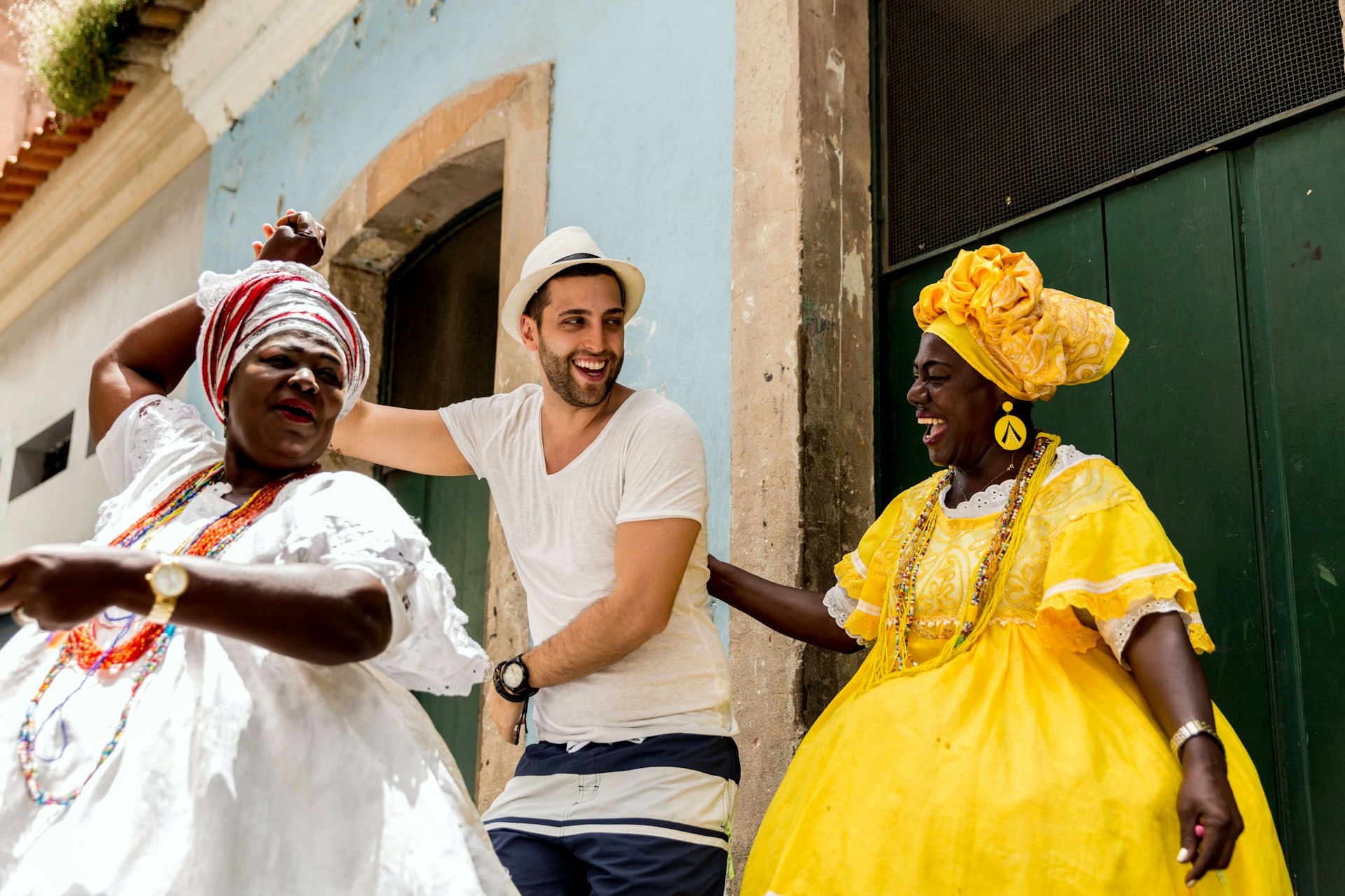 A traveler and locals dance on the streets of Pelourinho, Salvador, Bahia, Brazil