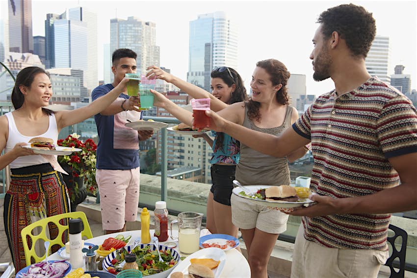 Friends enjoy barbecue on urban rooftops