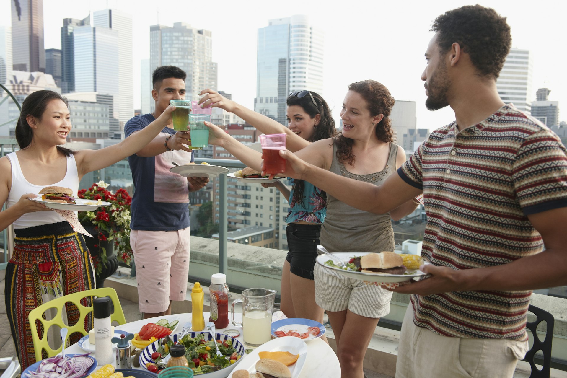 Friends enjoying barbecue on urban rooftop