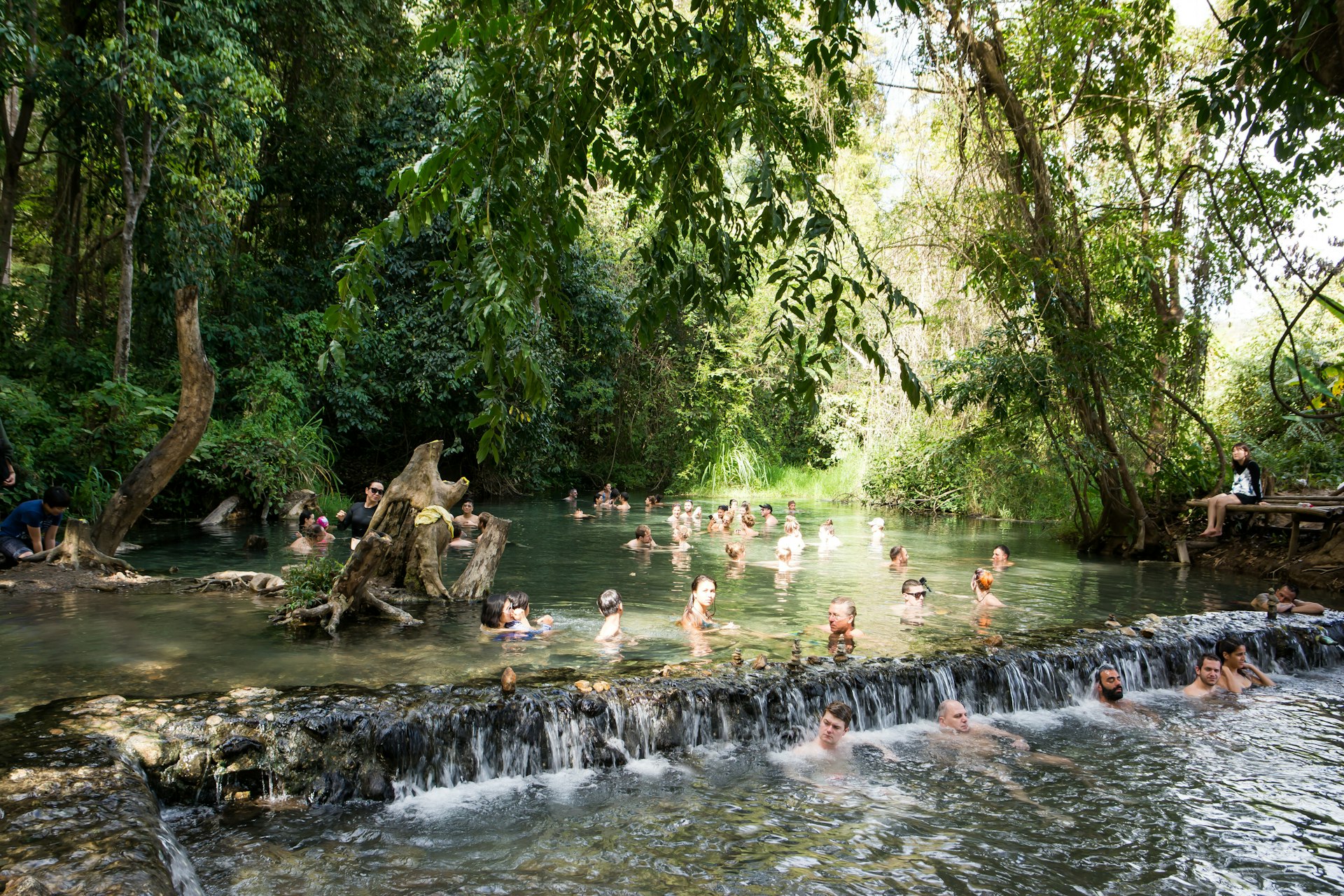 Travelers soaking in the Sai Ngam Hot spring near Pai Thailand
