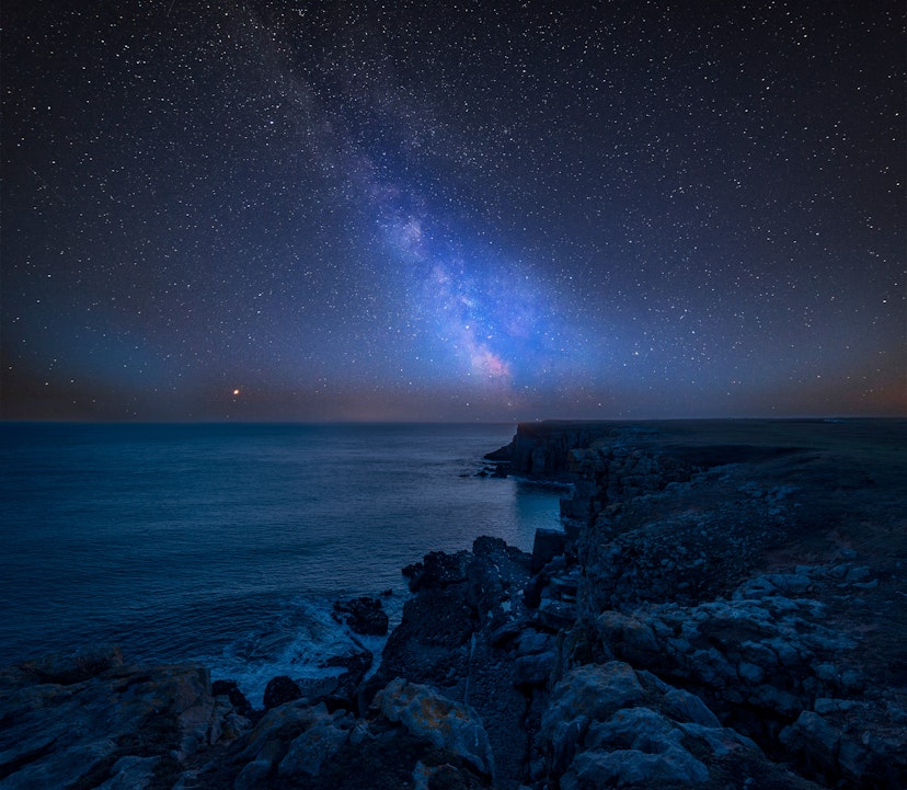 Milky Way in the night sky over a rocky coastal section near St Govan's Head on the Pembrokeshire Coast.