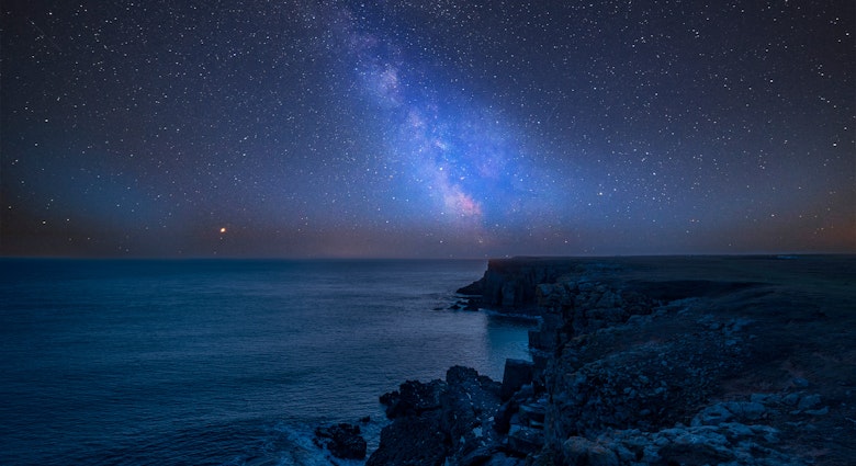 Milky Way in the night sky over a rocky coastal section near St Govan's Head on the Pembrokeshire Coast.