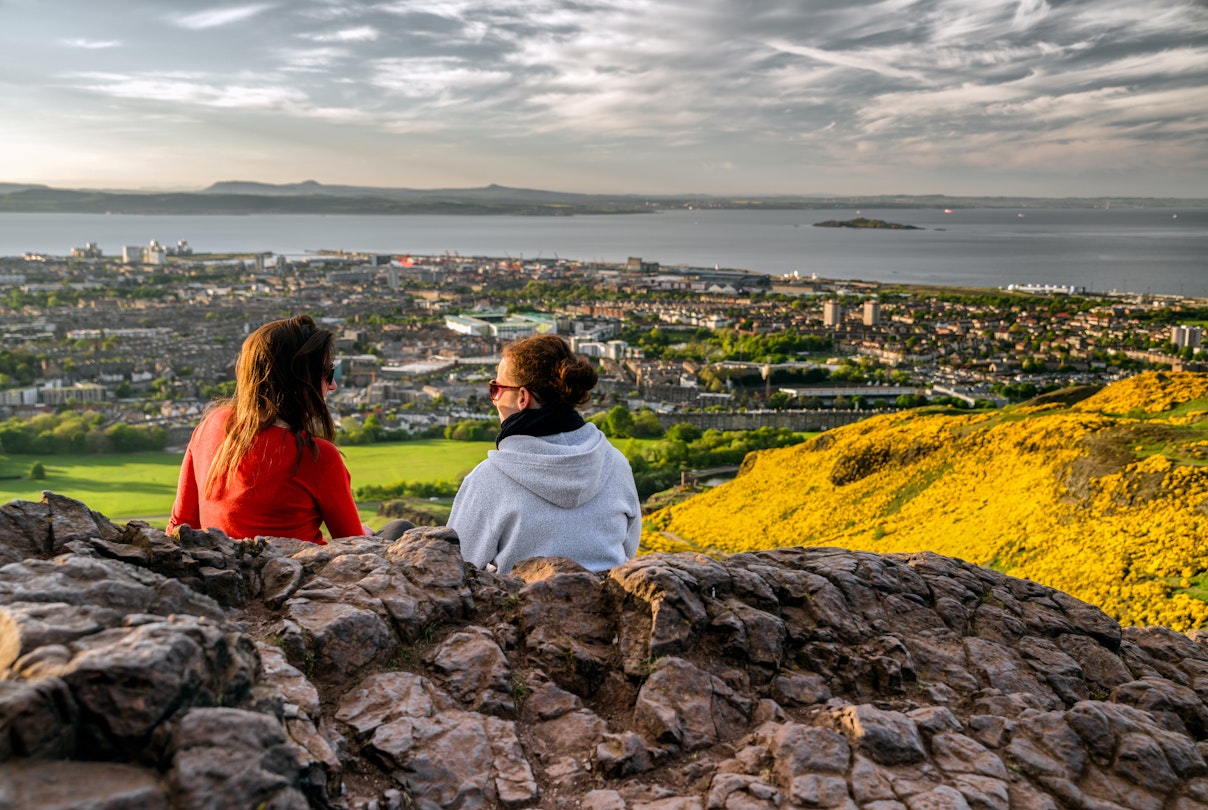 May 17, 2018: Girls sitting on the hill of Arthur's seat overlooking Edinburgh.