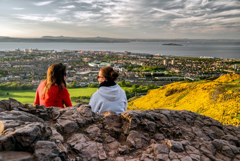 May 17, 2018: Girls sitting on the hill of Arthur's seat overlooking Edinburgh.