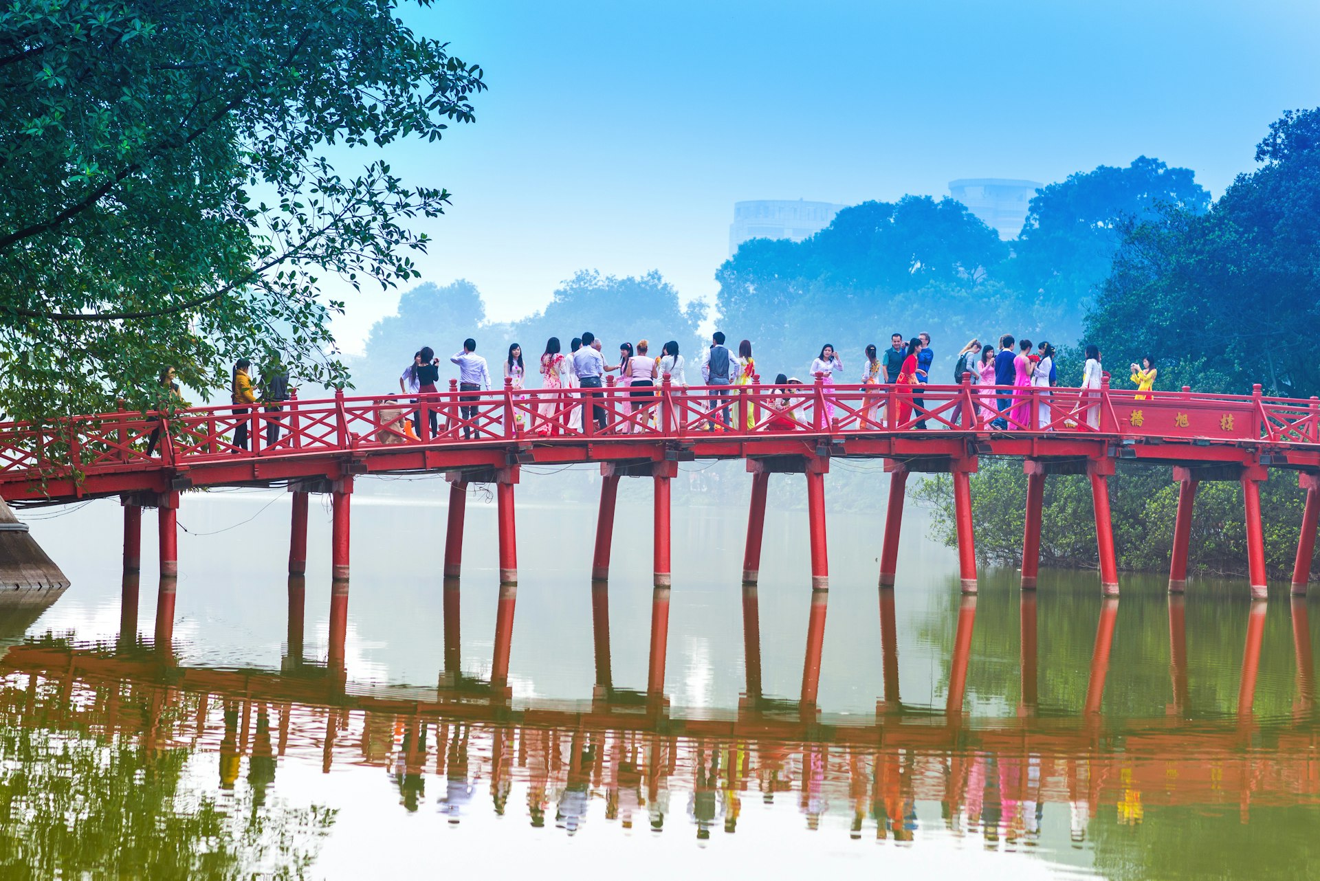 uc Bridge over the Hoan Kiem Lake .The wooden red-painted bridge connects the shore and the Jade Island on which Ngoc Son Temple