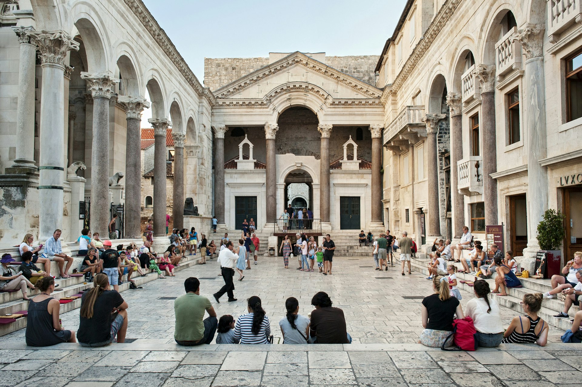 A Roman temple with many groups of visitors