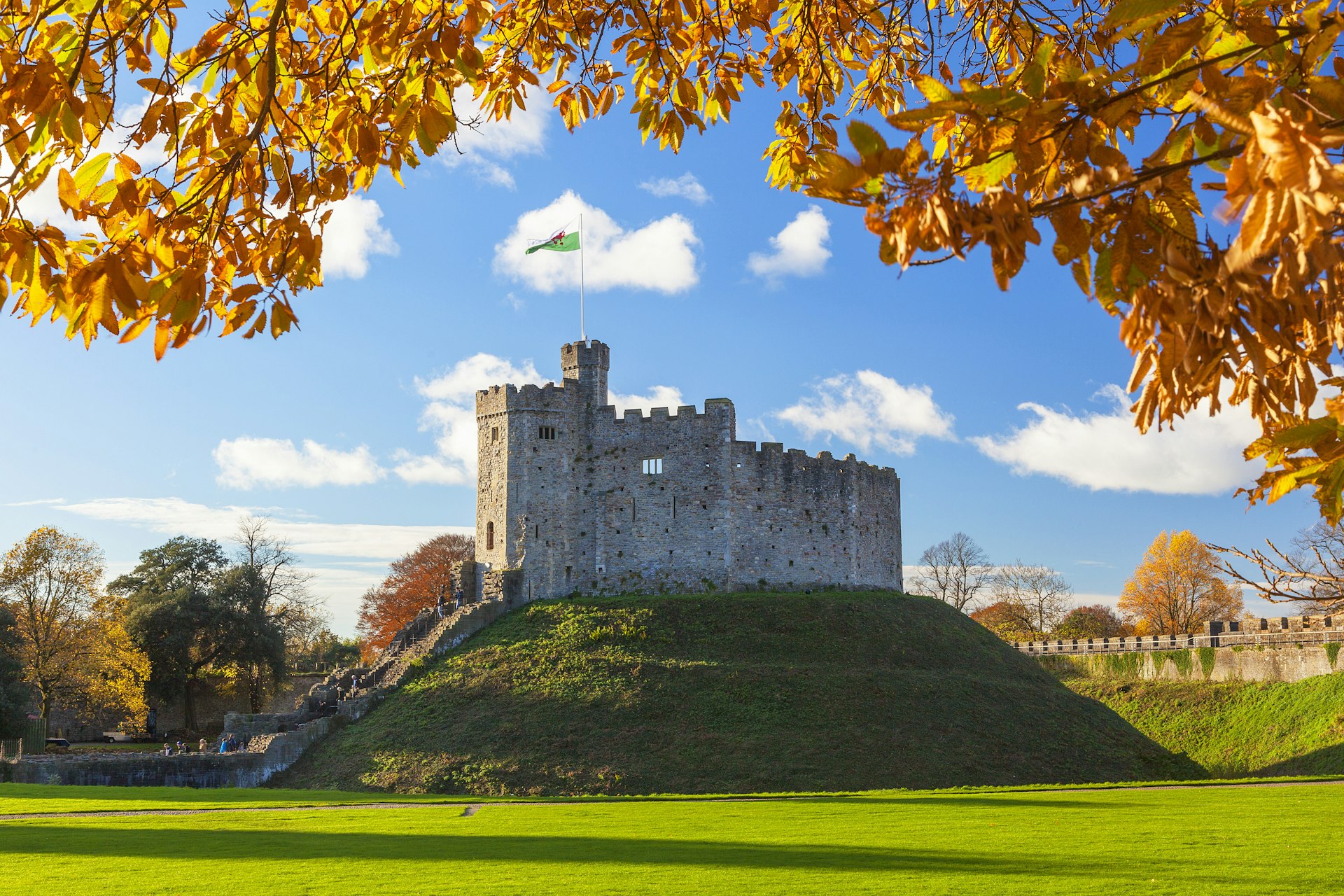 A round stone castle on a mound of green earth