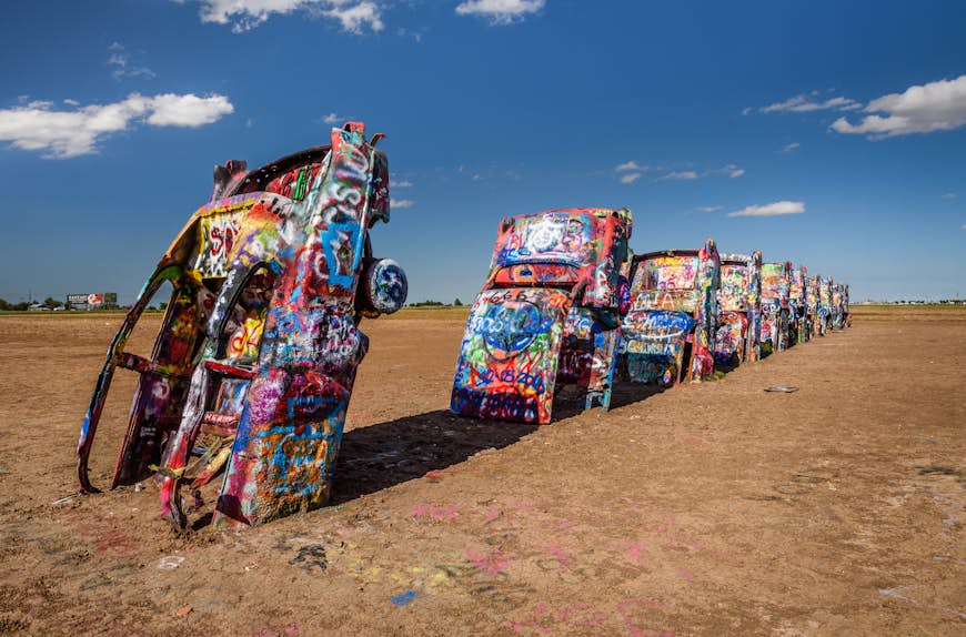 Colorful graffitied cars half buried in the ground at Cadillac Ranch, Amarillo
