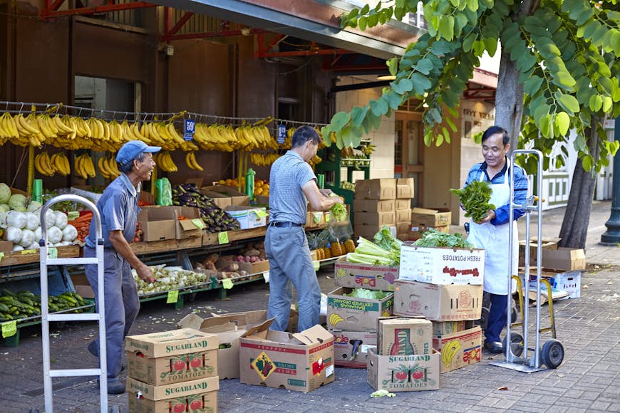 Fruit vendors with boxes of produce in Honolulu’s historic Chinatown, Hawaii