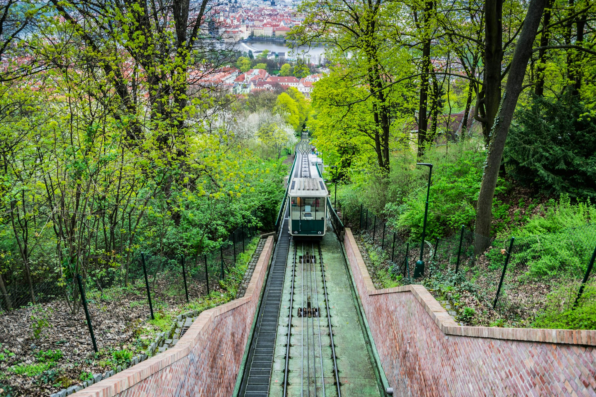 A shot down a funicular track towards a green train carriage