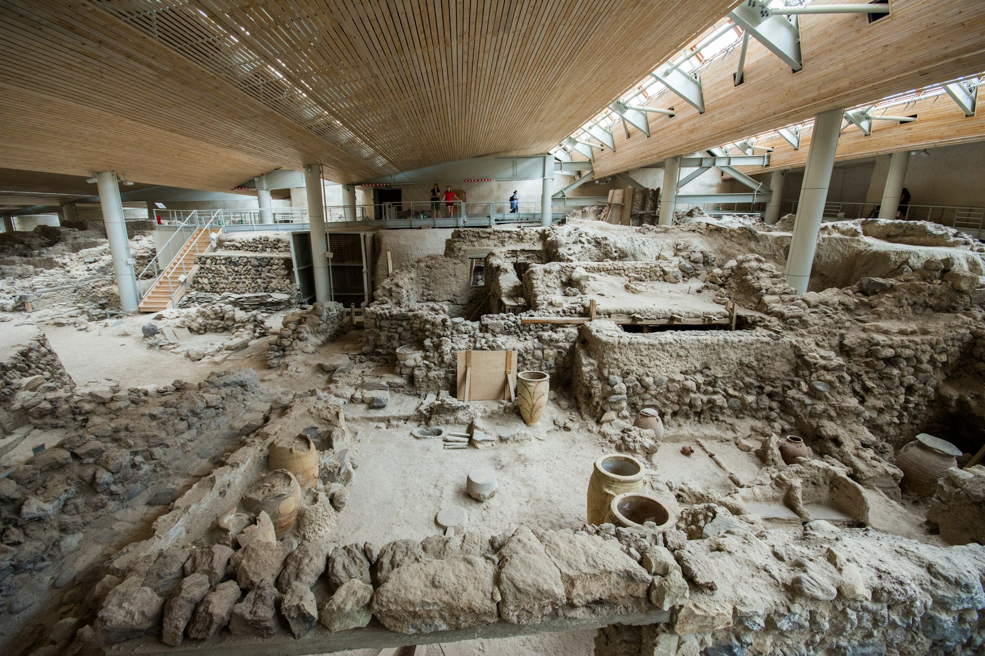 A vast archaeological site with ancient pots and walls on display