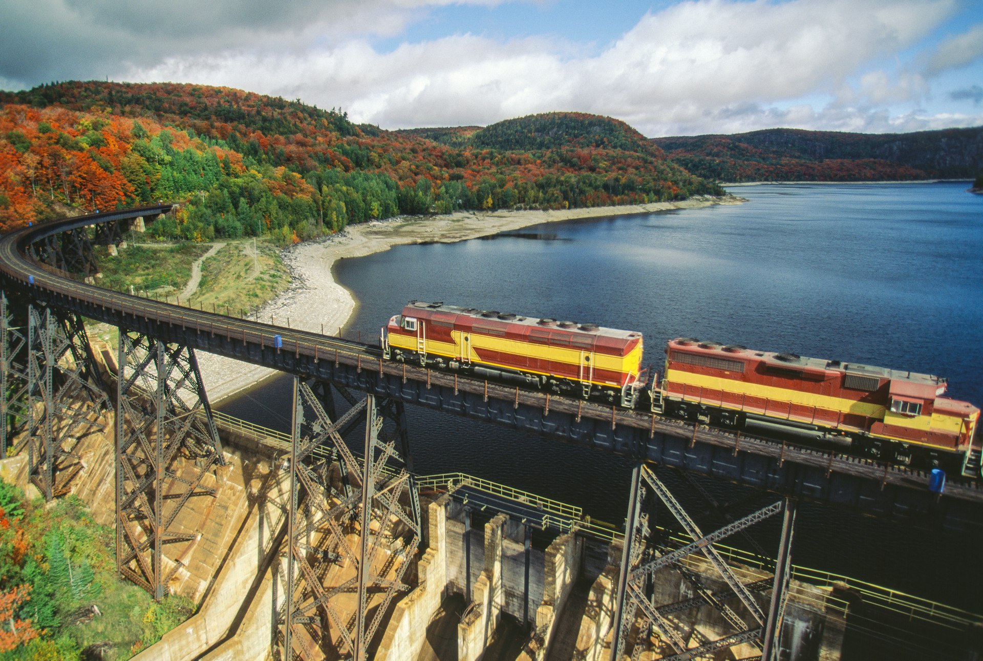 Agawa Canyon Train passing over a bridge surrounded by colorful fall foliage, Canada