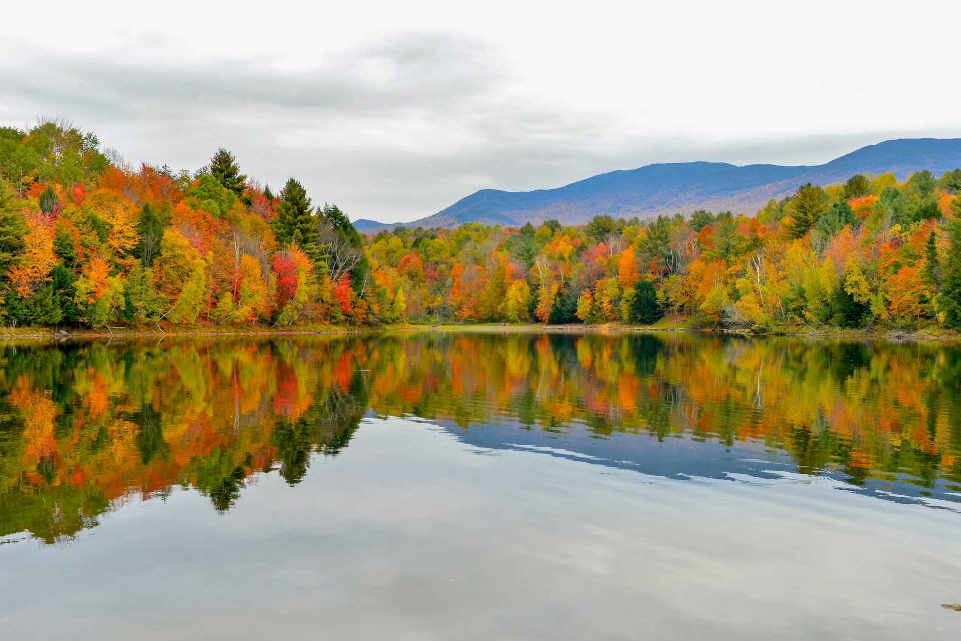 Autumn forest and mountains reflected in the Waterbury Reservoir near Stowe, Vermont