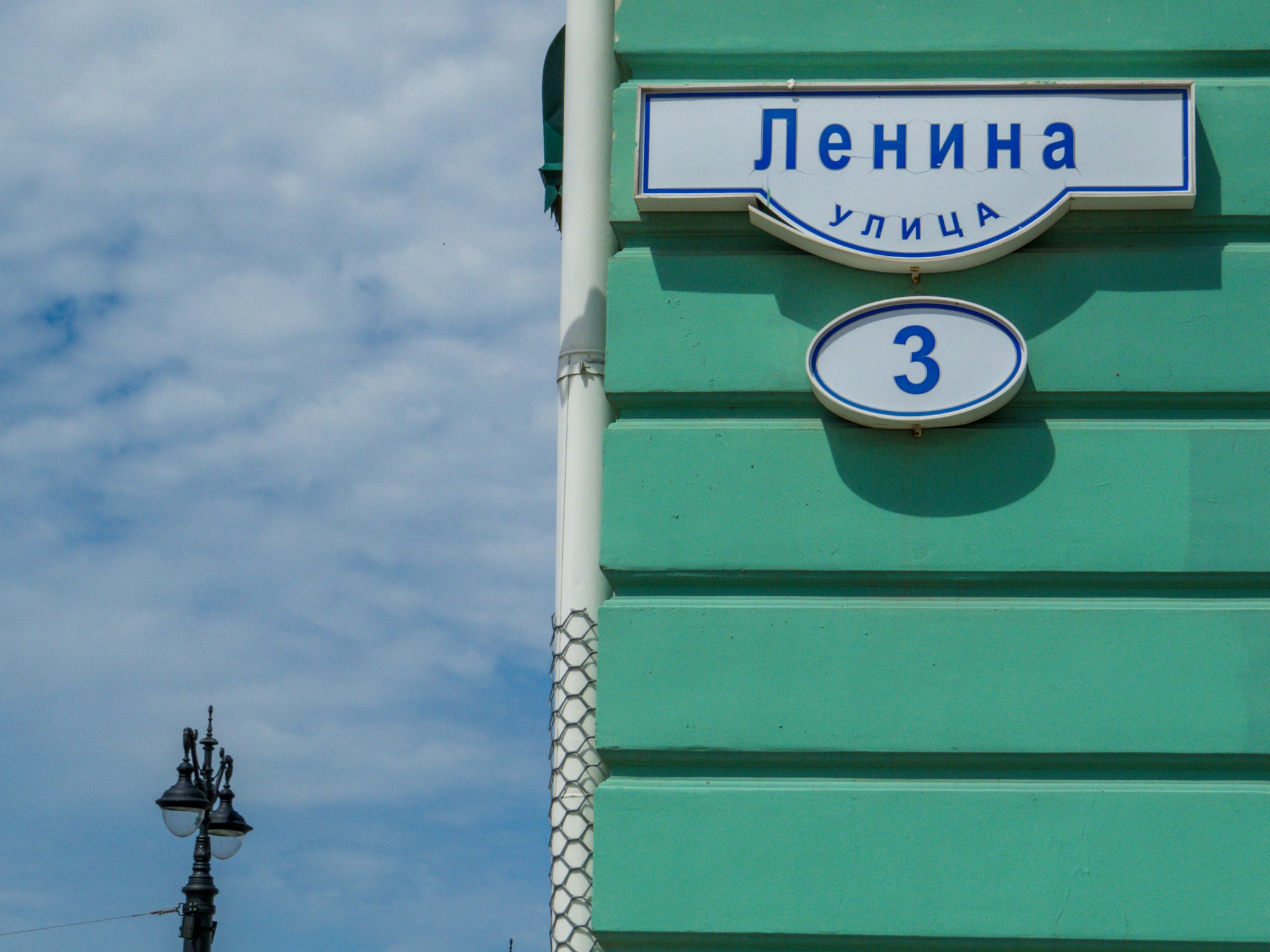A street sign with Cyrillic writing on the side of a building