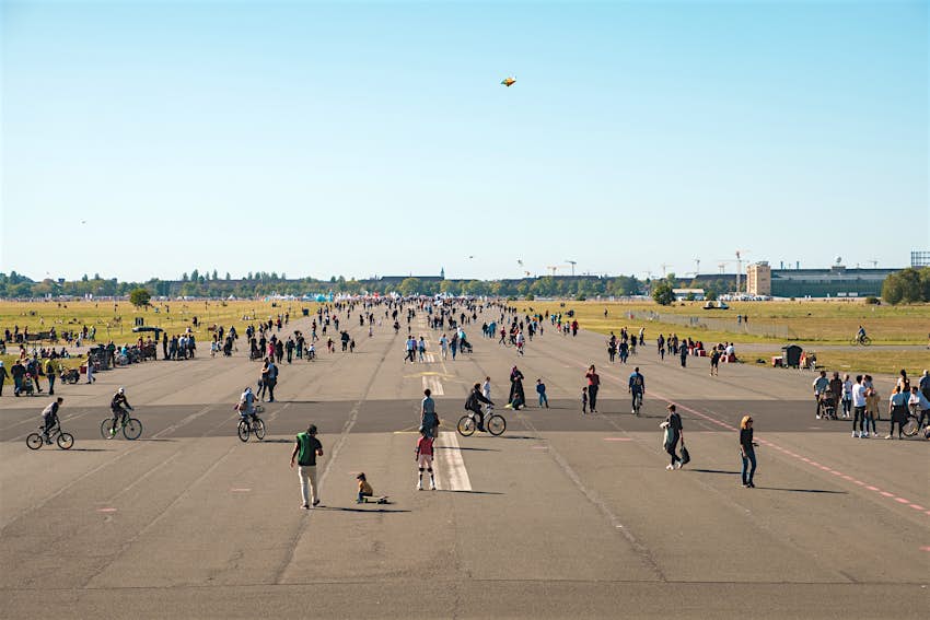 Pedestrians and cyclists walk on the runway of the abandoned Tempelhofer Feld airport in Berlin, Germany