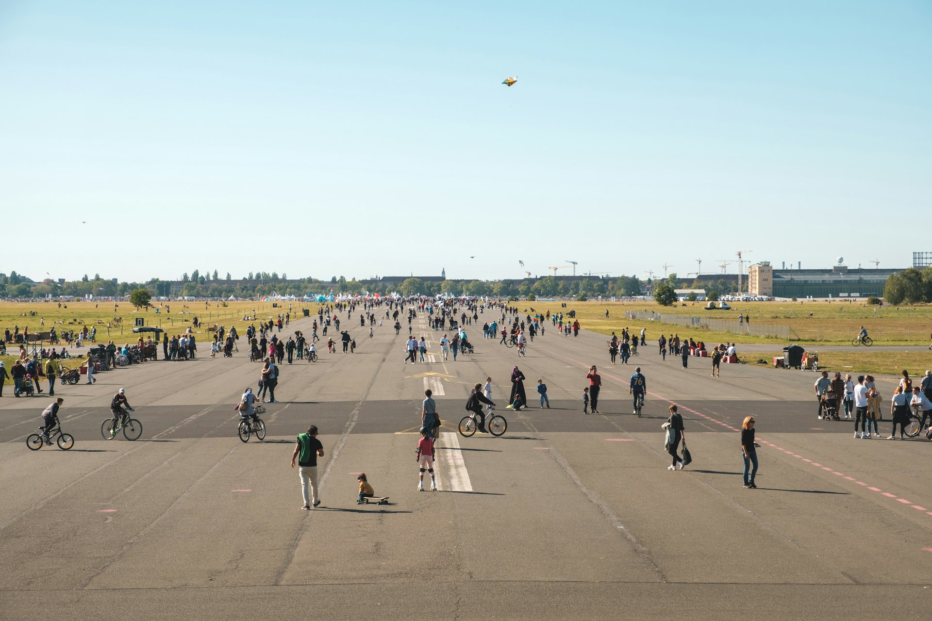 Pedestrians and cyclists walk on the runway of the abandoned Tempelhofer Feld airport in Berlin, Germany