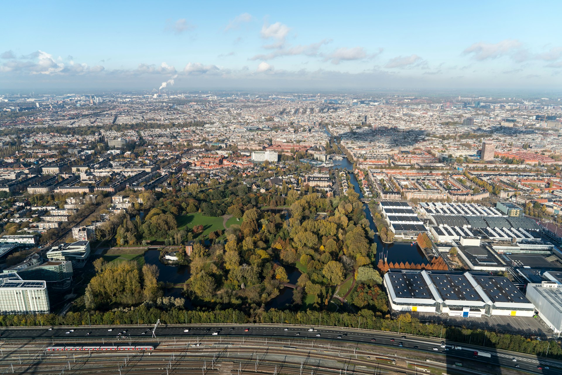 An aerial shot of a large wooded area surrounded by buildings