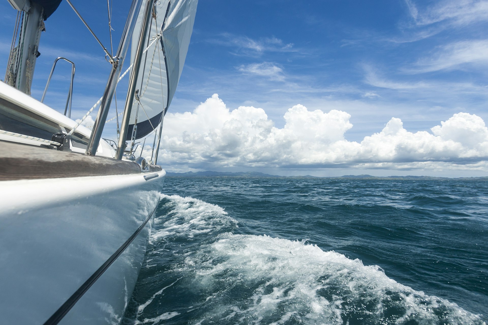 A pleasure yacht under full sail in Fiji, shot from the starboard side towards the bow