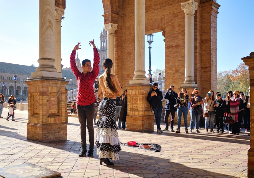 Tourists enjoy street flamenco traditional show, performance for spectators visitors at Plaza de Espana
