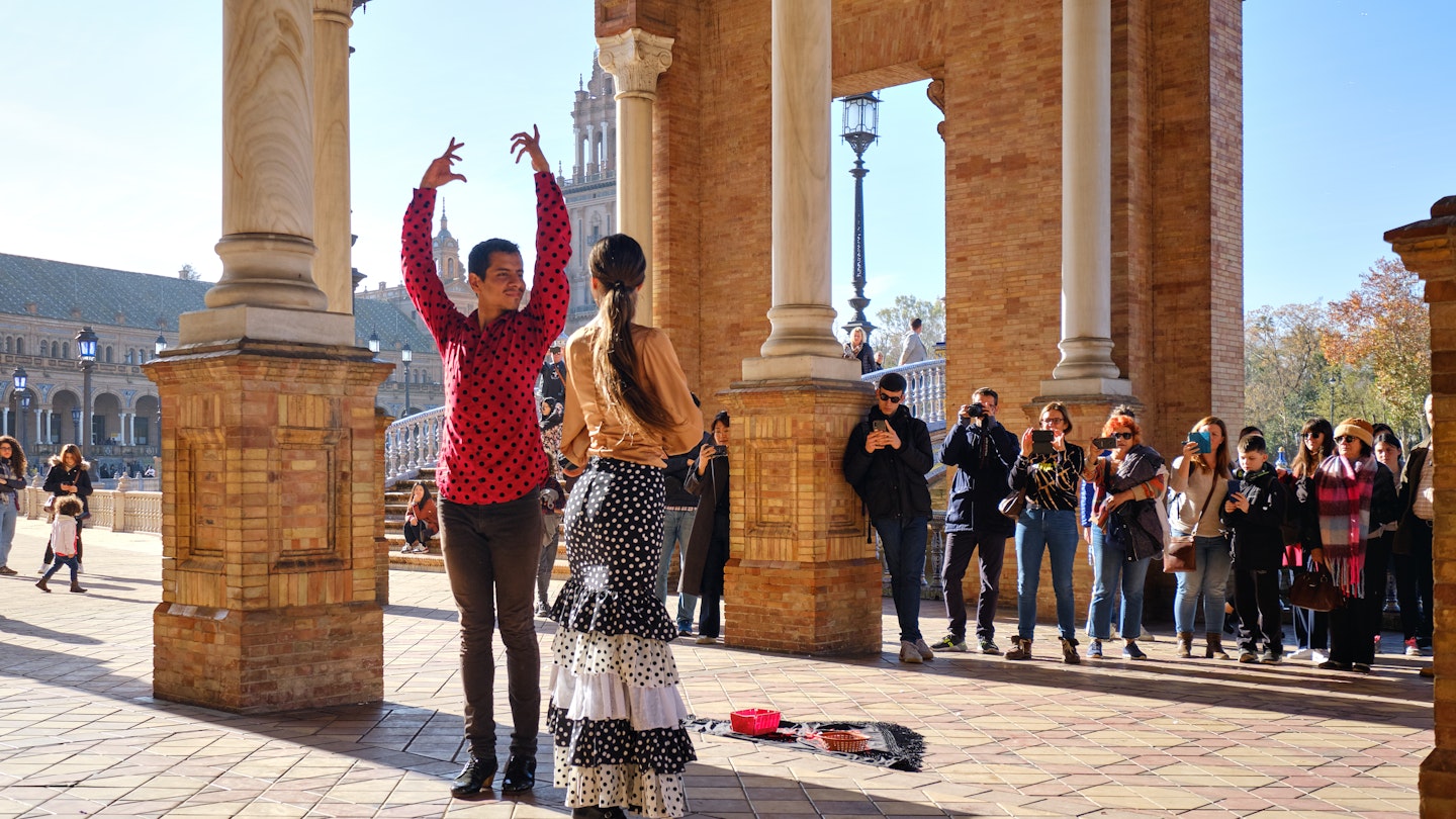 Tourists enjoy street flamenco traditional show, performance for spectators visitors at Plaza de Espana