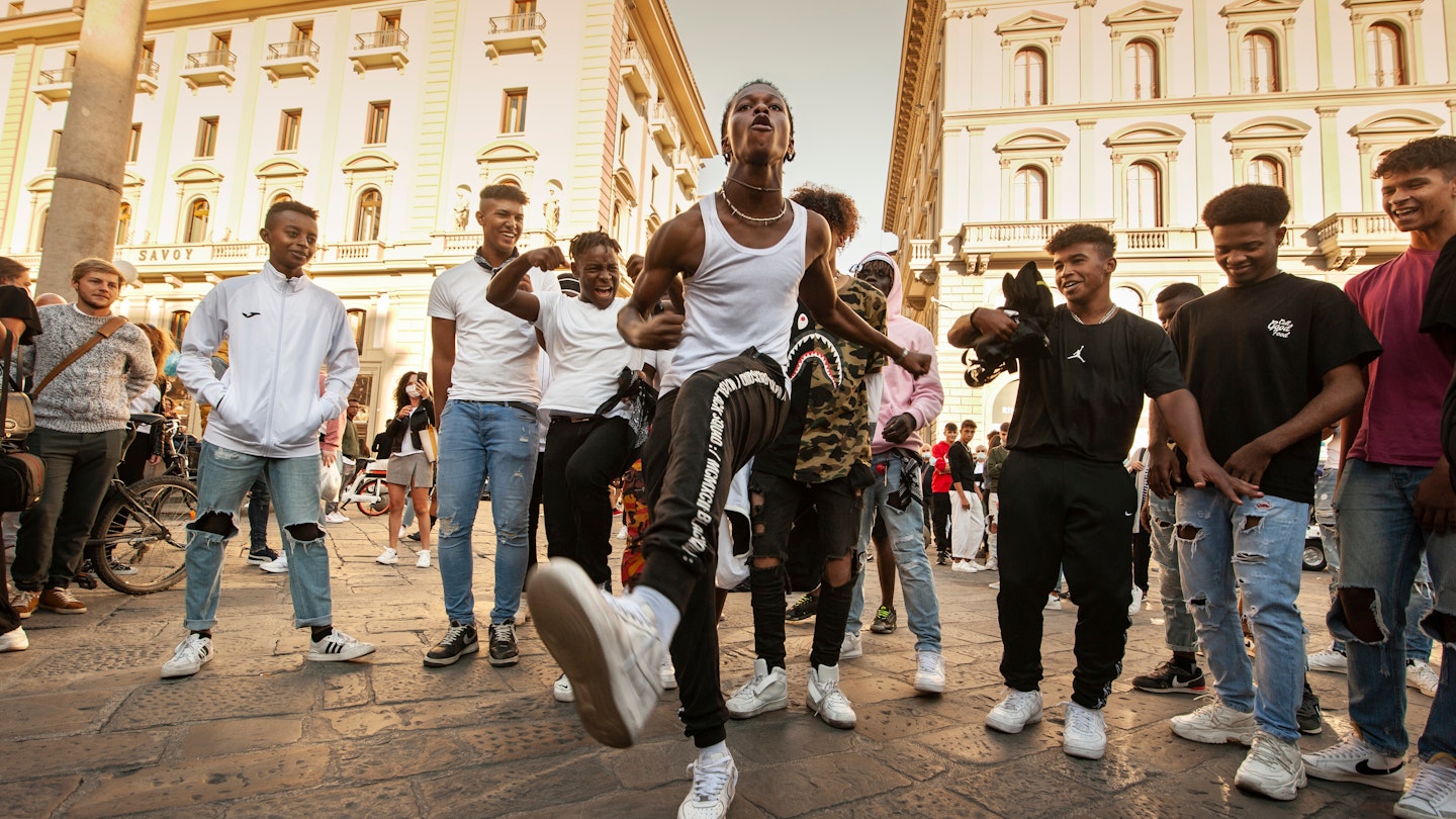 Unidentified B-boy break dancers perform in the street for the crowd. Hip Hop battle at an informal street dance meet.