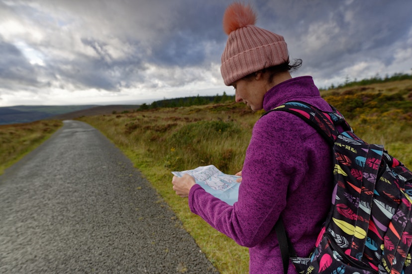 Side view of woman hiker.She reading a map in Wicklow mountains.Wicklow National Park, Ireland.