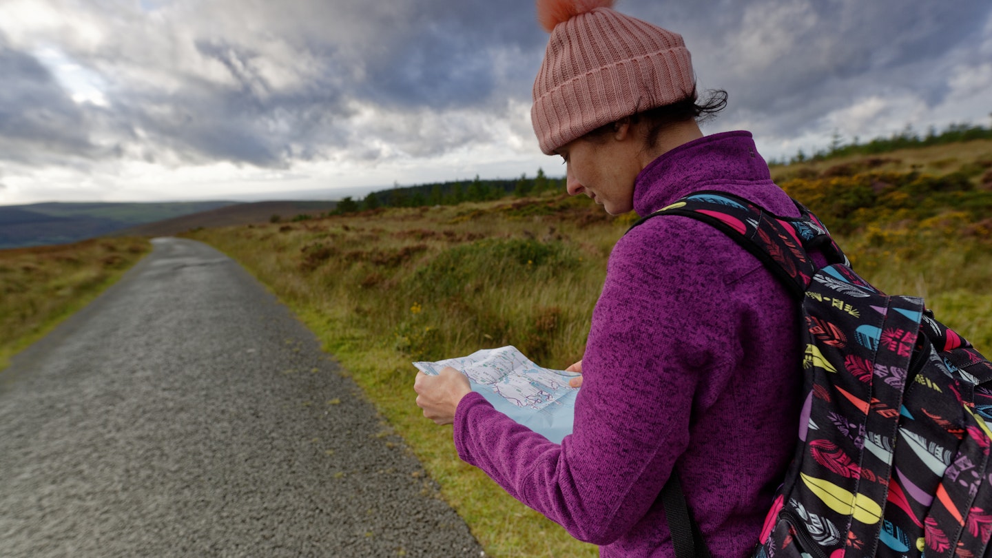 Side view of woman hiker.She reading a map in Wicklow mountains.Wicklow National Park, Ireland.
