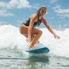 A young woman surfing on a sunny summers day in northern NSW, Australia
