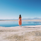 Chile, Atacama Desert, back view of woman standing on edge of Laguna Cejar