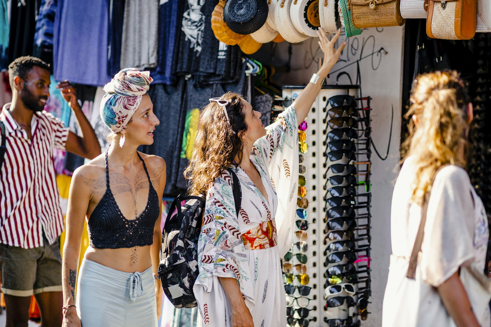 A group of friends browsing merchandise at market stalls while exploring in Bali, Indonesia