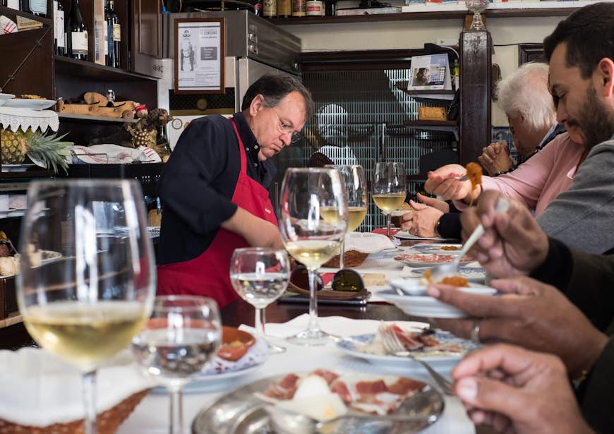 En man häller upp vin i en portugisisk vinbar. 