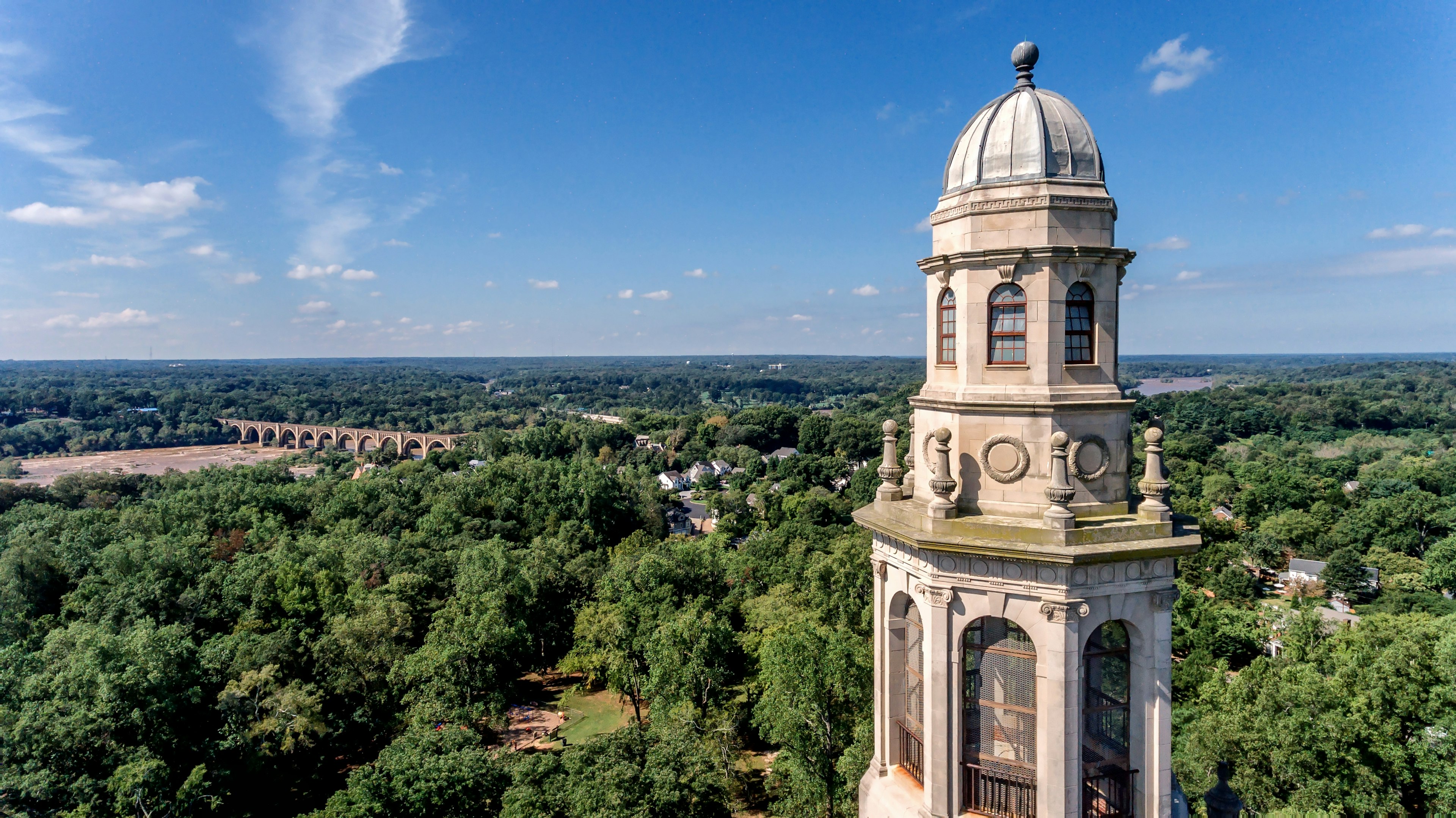 A view of the Carillon, a tall WWI memorial, located in Byrd Park. The surrounding parkland is visible in the background.