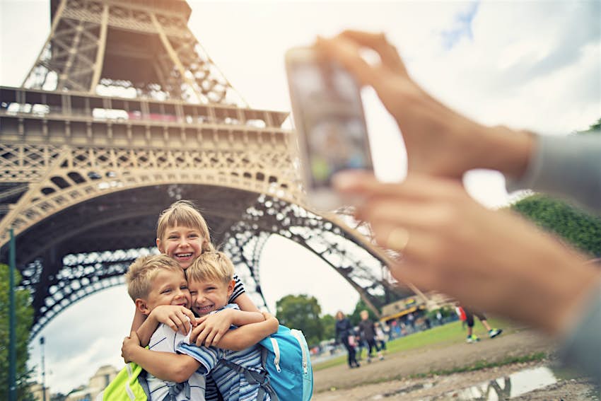 Touristes d'enfants souriant à la caméra près de la Tour Eiffel