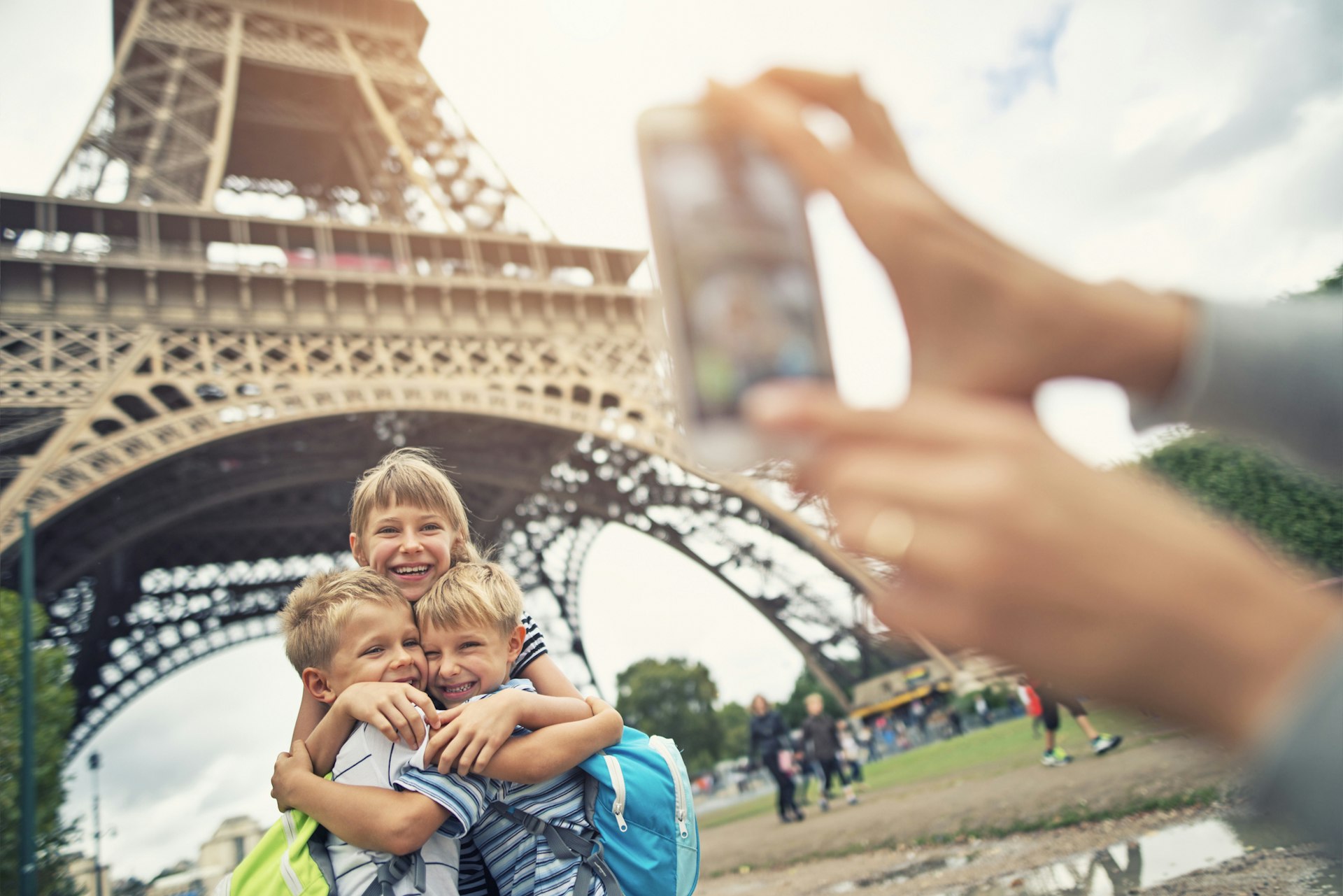 Kids tourists smiling at the camera near Eiffel Tower