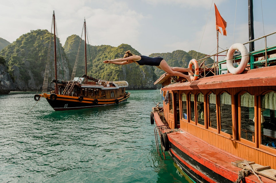 woman diving off of a boat in Halong Bay Vietnam