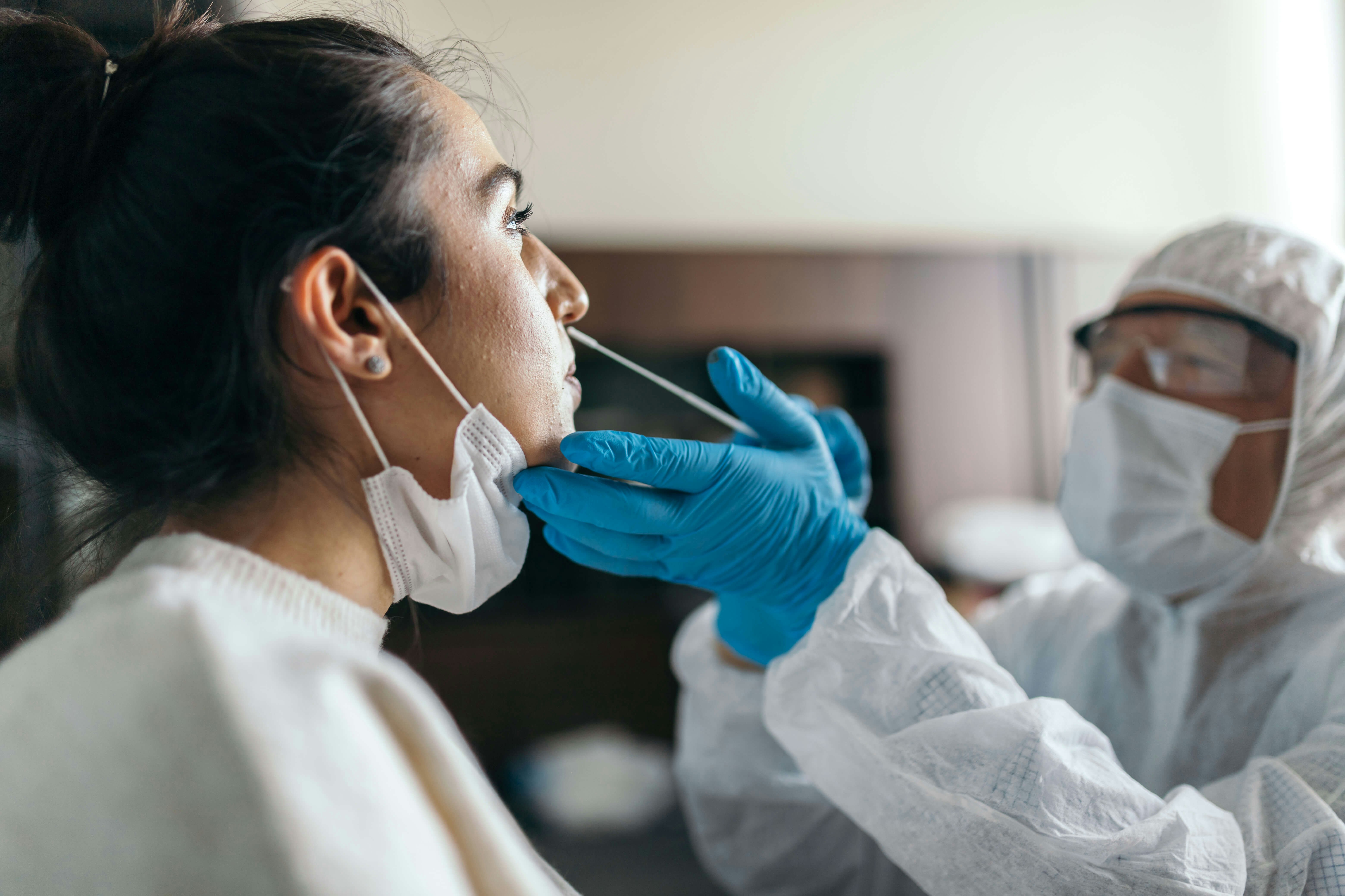 Doctor in protective workwear taking nose swab test from young woman Ergin Yalcin GettyImages-1285812726 rfc.jpg