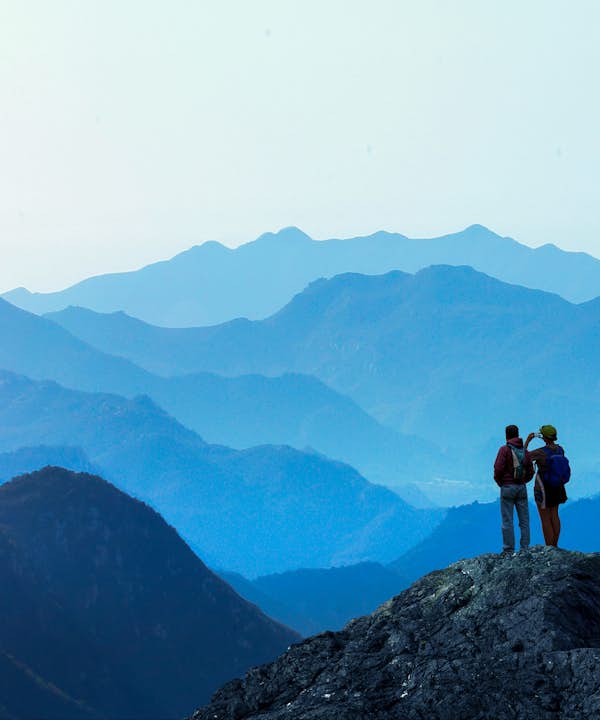 two people standing on mountain taking picture